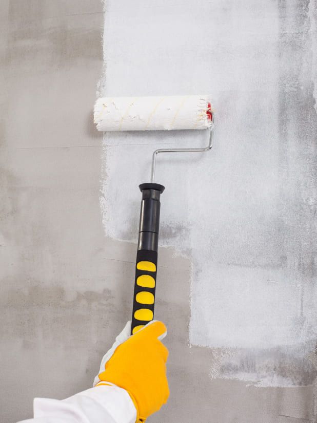 Eine Weiße Rolle wird über eine Wand gerollt